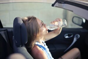 1 femeie in masina care bea apa